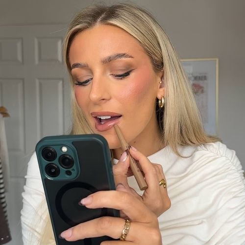 Model using phone camera to apply lipstick