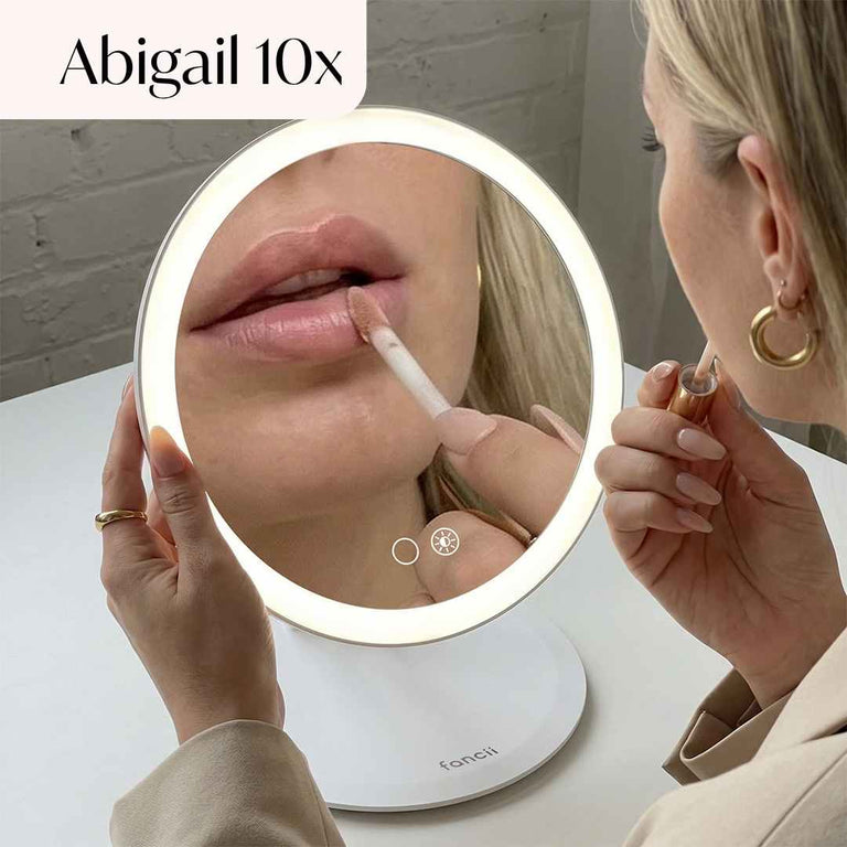 Abigail Lighted Compact in White Set up on desk and being used by model to apply lipstick