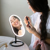Woman using Fancii's vera lighted vanity to apply skincare in Black