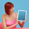 Woman showcasing the Aura Go 2 lighted makeup mirror for travel by Fancii and Co All