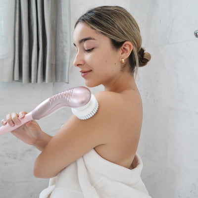 Woman using the Fancii Cora 7 body cleansing brush with handle