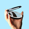Woman holding a Mini Lumi LED compact mirror with 1x/10x magnifying by Fancii and Co_Midnight Black