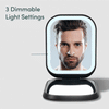 Mica Lighted Compact with built-in powerbank in Black Sesame color by Fancii and Co. The mirror is open and showcasing the 3 dimmable light settings while a male model looks into the mirror. 