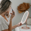 Woman using Fancii and Co's vera lighted vanity to apply makeup in Rose Gold
