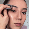 Female using Zoe EYE makeup remover to remove waterproof mascara