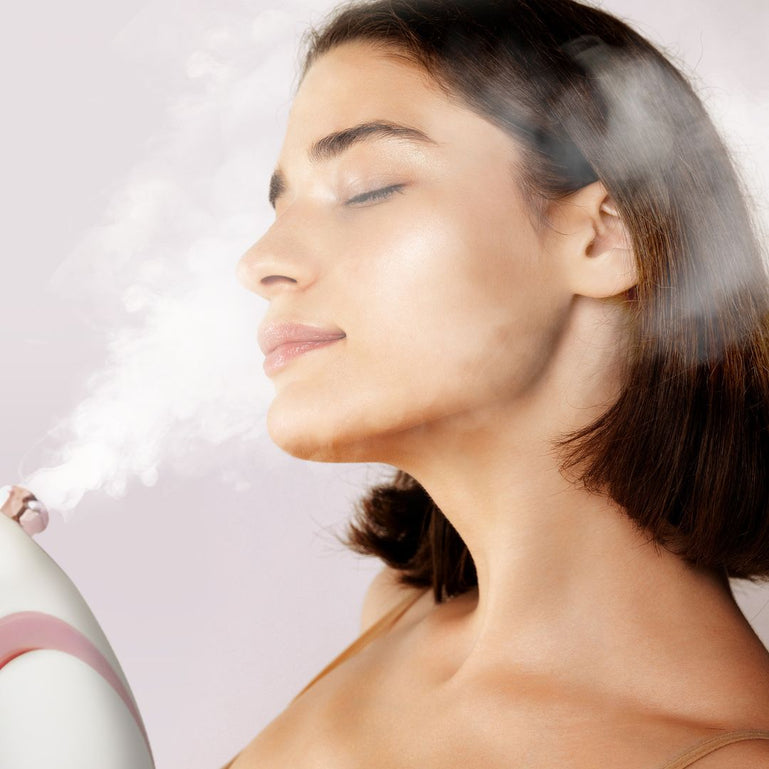 Woman using the Rivo facial steamer for at-home facials All